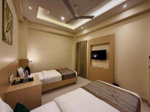 een hotelkamer met twee bedden en een tv bij RION - A Boutique Hotel in Udaipur