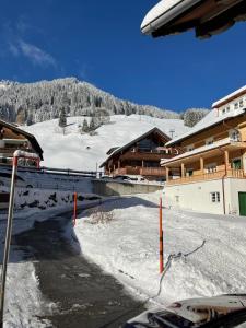 a ski slope with snow and a ski lodge at Alpenheimat 1658 in Mittelberg