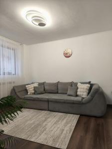 a living room with a gray couch in a white room at Apartament Belvedere in Galaţi