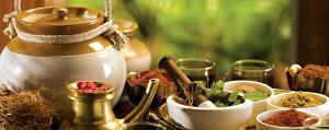 a table topped with bowls of spices and a jar at Somatheertham Resort in Kovalam