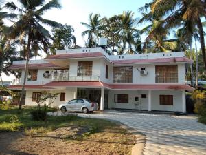 a house with a car parked in front of it at Somatheertham Resort in Kovalam +28 photos