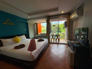 a bedroom with a bed and a television and a balcony at PorterHouse Beach Hotel in Patong Beach +82 photos