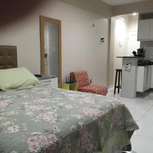 1 dormitorio con 1 cama y 1 silla y cocina en Stúdio Beira Mar 1004, en Fortaleza