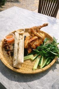 een mand met eten, kip en groenten op een tafel bij Han San Homestay Măng Đen in Kon Plong