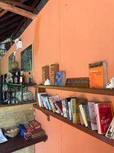 a shelf filled with books on an orange wall at Bamboo Hideaway Resort in Ko Mak