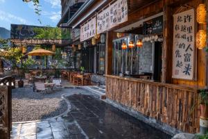 a restaurant with tables and chairs outside of a building at Phoenix Ancient Hill Riverside View Hotel- Offers free one-way high-speed rail pick-up service - Afternoon tea - Self-service laundry - Baggage storage - Travel planning in Fenghuang County