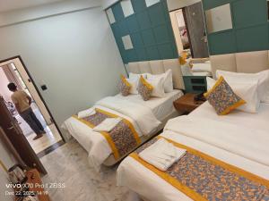 a hotel room with two beds and a mirror at KDM Hotel Indore Palace- a walk away from Saibaba Temple in Shirdi +47 photos