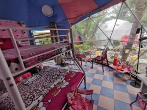 a room with bunk beds and a table and chairs at Groups & Families Glamping Dome Beach Resort Dauin in Dauin