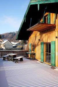 a building with picnic tables and benches on a deck at haus nummer fünf - inklusive Chiemgau Karte in Siegsdorf