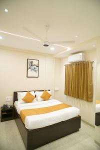 una camera da letto con un letto grande in una stanza di The Residency Inn Visawa Kolhapur a Kolhapur
