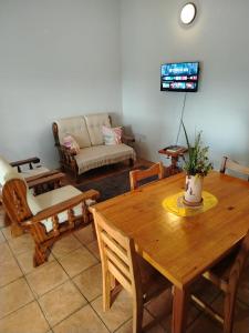 a living room with a wooden table and chairs at Heights in Cedara