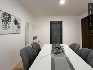 a dining room with a white table and chairs at Second Home - Kota Kemuning in Shah Alam
