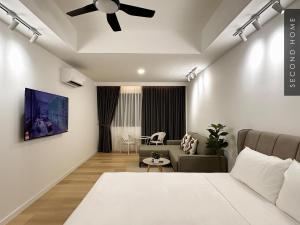 a bedroom with a ceiling fan and a living room at Second Home - Kota Kemuning in Shah Alam