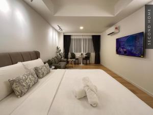 a bedroom with a large white bed and a living room at Second Home - Kota Kemuning in Shah Alam +21 photos