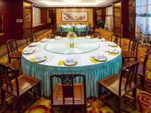 a large table in a room with chairs and a table at Hangzhou Blossom Hotel in Xiaoshan