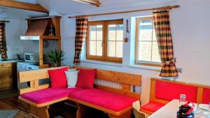a living room with a bench with red cushions at Ferienwohnung Gräßl - Almzeit in Preitenegg