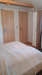 a bedroom with two doors and a large bed at Ferienwohnung Gräßl - Almzeit in Preitenegg