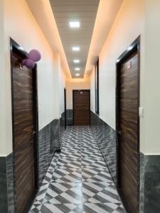 a hallway with wooden doors and a checkered floor at Hotel Sobhagyam in Kekri