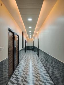 a hallway with a tile floor and wooden doors at Hotel Sobhagyam in Kekri