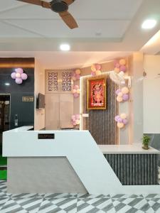 a lobby with a white counter with pink balloons at Hotel Sobhagyam in Kekri +1 photo