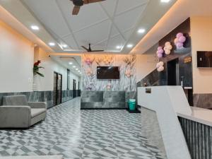 a lobby with a couch and a tv on a wall at Hotel Sobhagyam in Kekri
