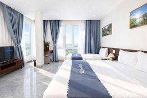 a hotel room with two beds and a flat screen tv at The Sun Hotel Pho Co Ninh Binh in Ninh Binh