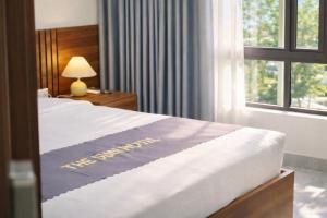 a hotel room with a bed and a window at The Sun Hotel - Ninh Bình in Kỳ Vĩ