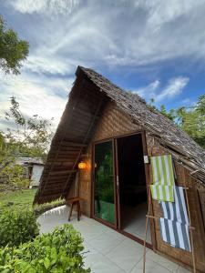 a small house with a thatched roof and an open door at 6227 Guesthouse in San Juan +30 photos
