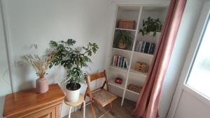 a room with a desk and a book shelf with plants at La Ferme du Papillon in Pougne-Hérisson