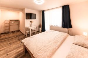 a bedroom with a bed and a table and a window at INLE Homestay in Nová Lesná