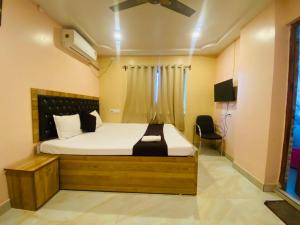 a bedroom with a bed and a tv in it at Hotel Mahal in Uchalon
