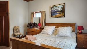 a bedroom with a bed and a chair and a mirror at La Casa in Napier