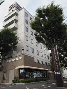 un percorso alberghiero in un edificio con un albero di fronte di Hotel Route-Inn Court Matsumoto Inter a Matsumoto