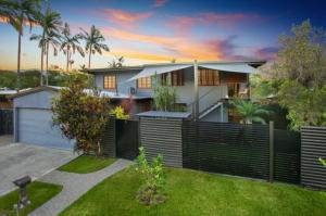 een huis met een hek voor een tuin bij Queenslander leafy Whitfield in Edge Hill