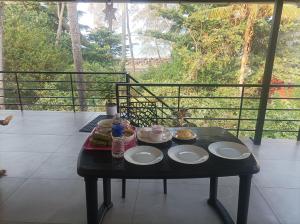a table with plates of food on a balcony at Kghomestay in Pallipuram +13 photos