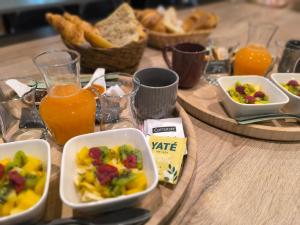 una tavola ricoperta di ciotole di cibo e succo d'arancia di Écrin de nature sous les pins ad Aurons Altre 75 foto