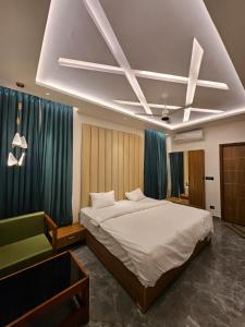 ein Schlafzimmer mit einem großen Bett und einem grünen Sofa in der Unterkunft Kurunchi Malar Resorts in Hosur