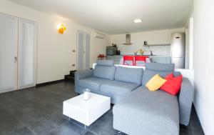 een woonkamer met een blauwe bank en rode en gele kussens bij La Filanda di Viano in Villa in Tremezzo