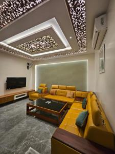 ein Wohnzimmer mit Sofa und Fernseher in der Unterkunft Kurunchi Malar Resorts in Hosur