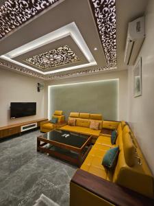 ein Wohnzimmer mit Sofa und Fernseher in der Unterkunft Kurunchi Malar Resorts in Hosur