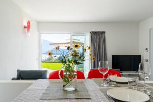 een eetkamer met een tafel met een vaas met bloemen bij La Filanda di Viano in Villa in Tremezzo