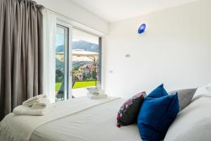 een slaapkamer met een bed met een groot raam bij La Filanda di Viano in Villa in Tremezzo +27 foto's
