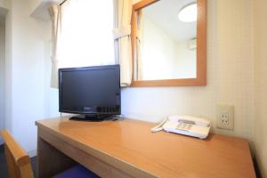 a desk with a television and a telephone on it at Hotel Musashino no Mori in Fuchu +12 photos