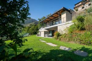 een huis op een heuvel met een grasveld bij La Filanda di Viano in Villa in Tremezzo