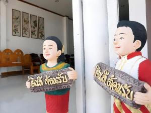 two statues of two people holding a sign at Thongphaphum Place in Thong Pha Phum