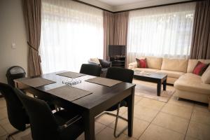 un soggiorno con un tavolo e un divano di Amohela Guesthouse a Midrand Altre 19 foto