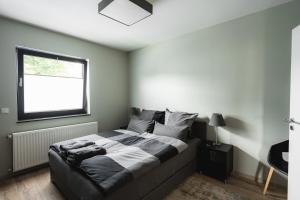 een slaapkamer met een groot bed en een raam bij NürbLife Hotel in Nürburg