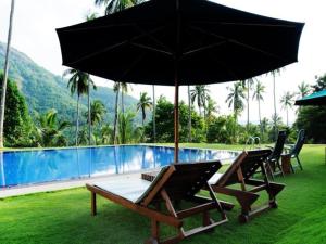 a pool with two chairs and an umbrella at Brook Boutique in Madahapola