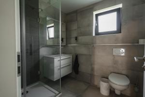 een badkamer met toilet en glazen douche bij NürbLife Hotel in Nürburg