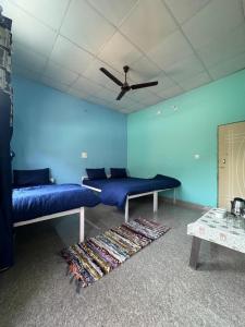 a room with two beds and a ceiling fan at Maasa Retreat & Resort in Shivpuri +98 photos